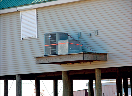 Example of an HVAC mounted on a cantilevered platform attached to a home elevated on an open foundation.
