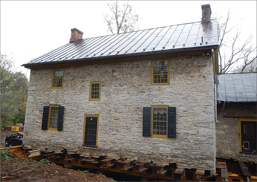 A stone house set into its new foundation.