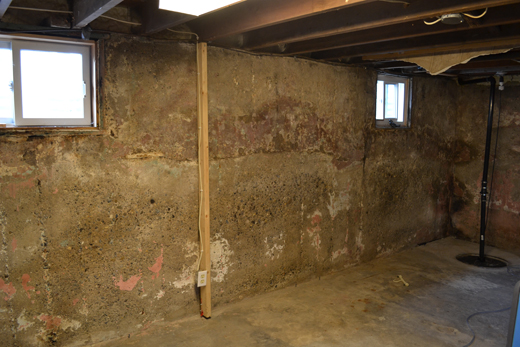 Clean basement after flooding due to sewer backup, with sump pump in the corner.