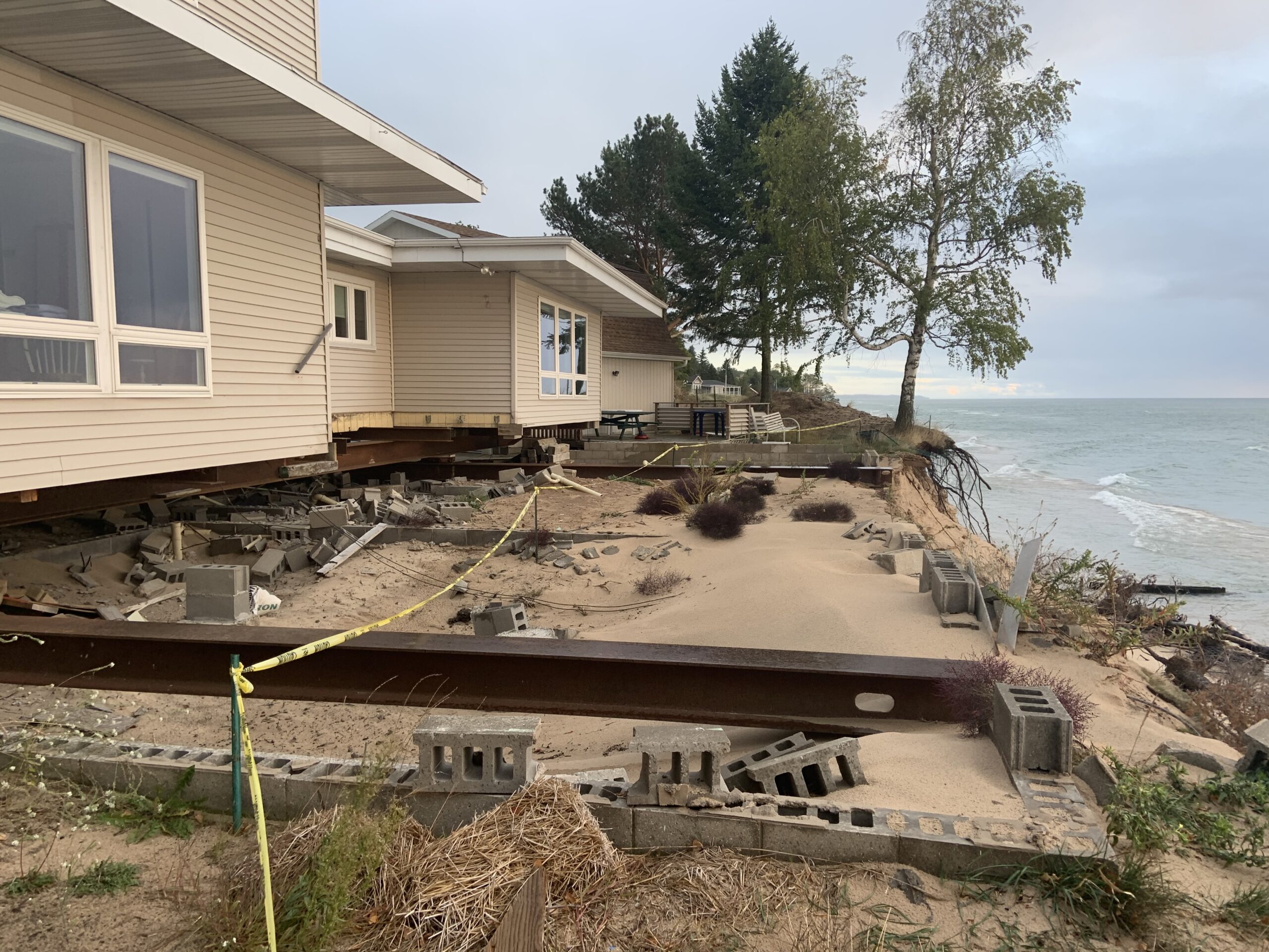 A house on metal cribbing being moved away from an eroding cliff. 