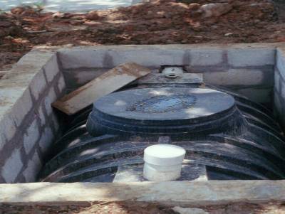 A septic tank installed in a concrete masonry unit (CMU) lined pit.